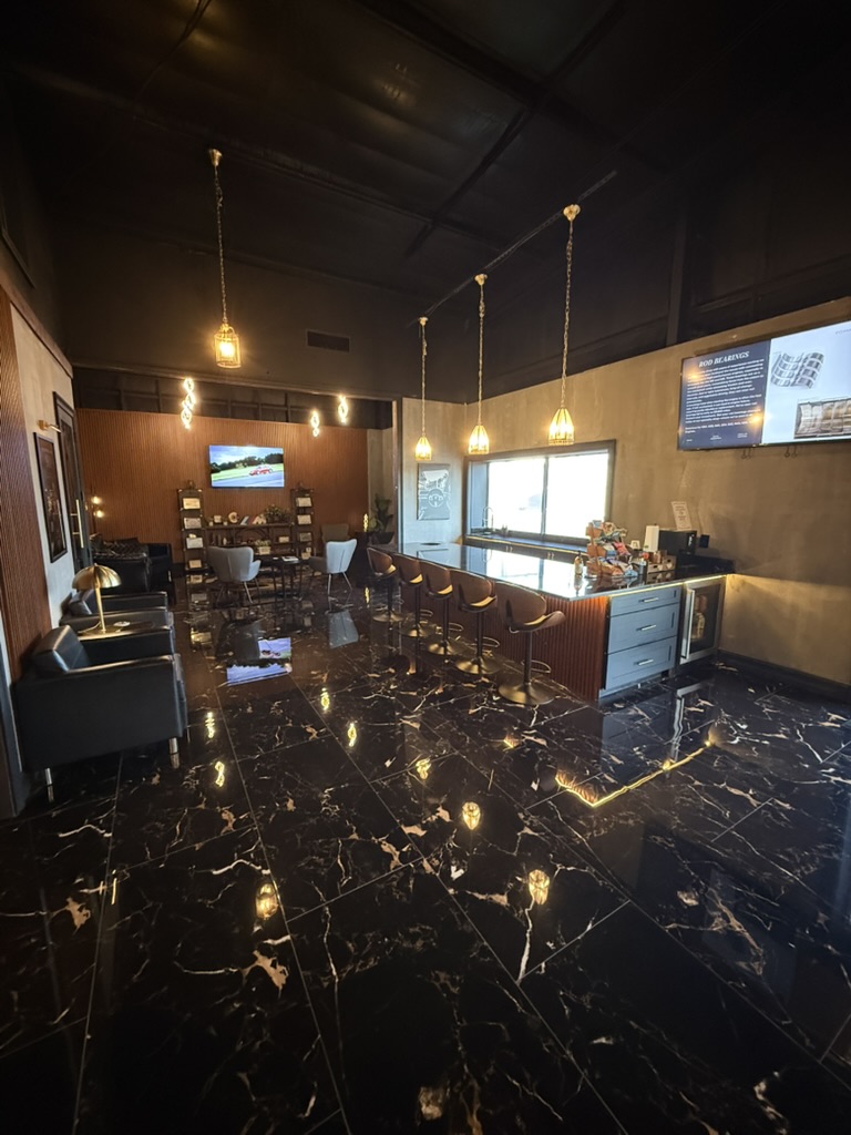 Renovated Fox Motors customer waiting area with lounge seating, coffee bar and warm pendant lighting